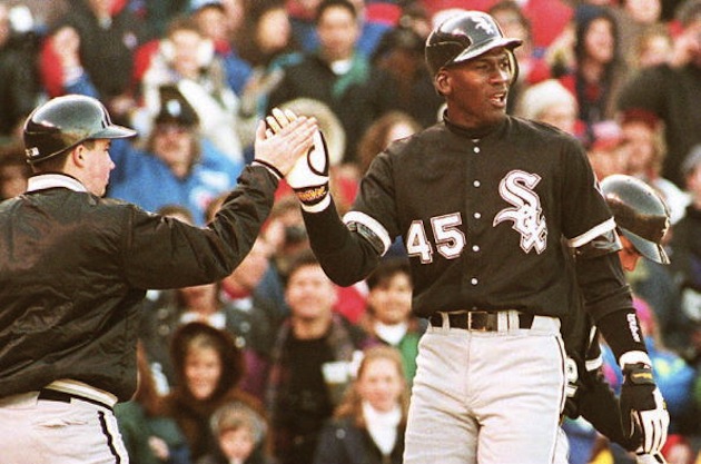 CHICAGO, IL - APRIL 7: Chicago White Sox outfielder Michael Jordan (R) is greeted by a unidentified batboy at Chicago's Wrigley Field, 07 April 1994, after scoring on a sixth inning home run during a crosstown exhibition game against the Cubs. Jordan, who will return to the minor leagues after the game, had two hits as the teams tied 4-4. (Photo credit should read EUGENE GARCIA/AFP/Getty Images)